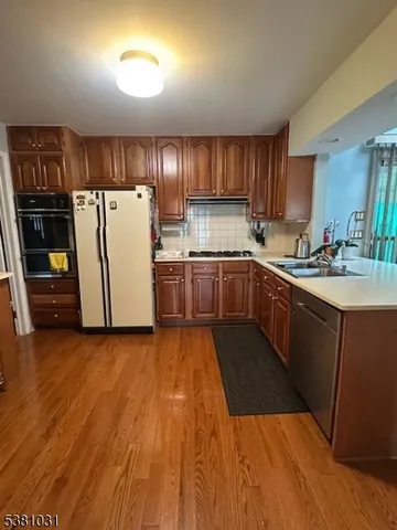a kitchen with a sink a refrigerator and cabinets