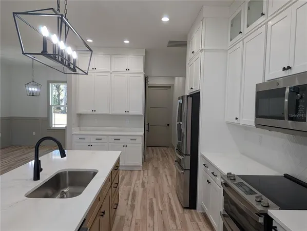 a kitchen with kitchen island a sink appliances and cabinets