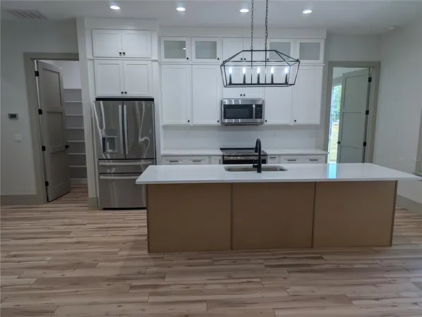 a kitchen with stainless steel appliances granite countertop a refrigerator a stove and a sink