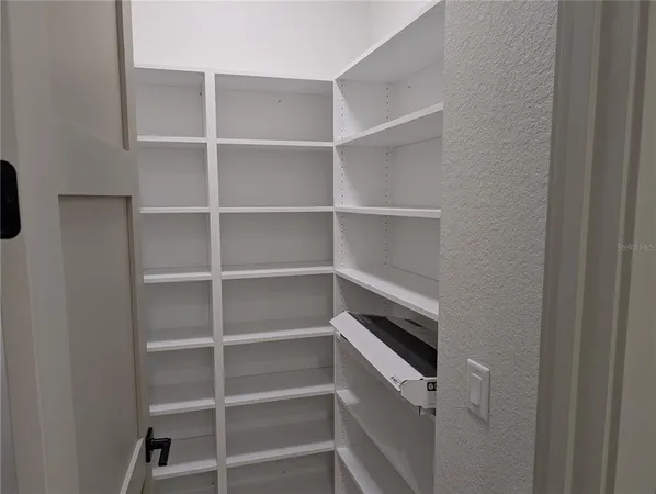 a view of walk in closet with empty racks