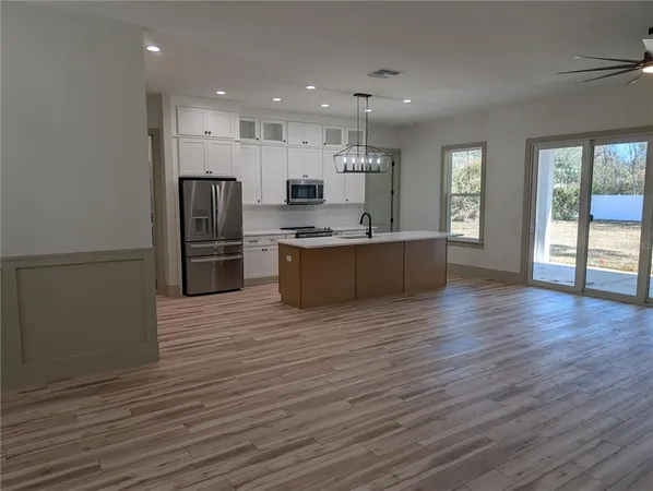a large kitchen with stainless steel appliances granite countertop a refrigerator and a stove top oven