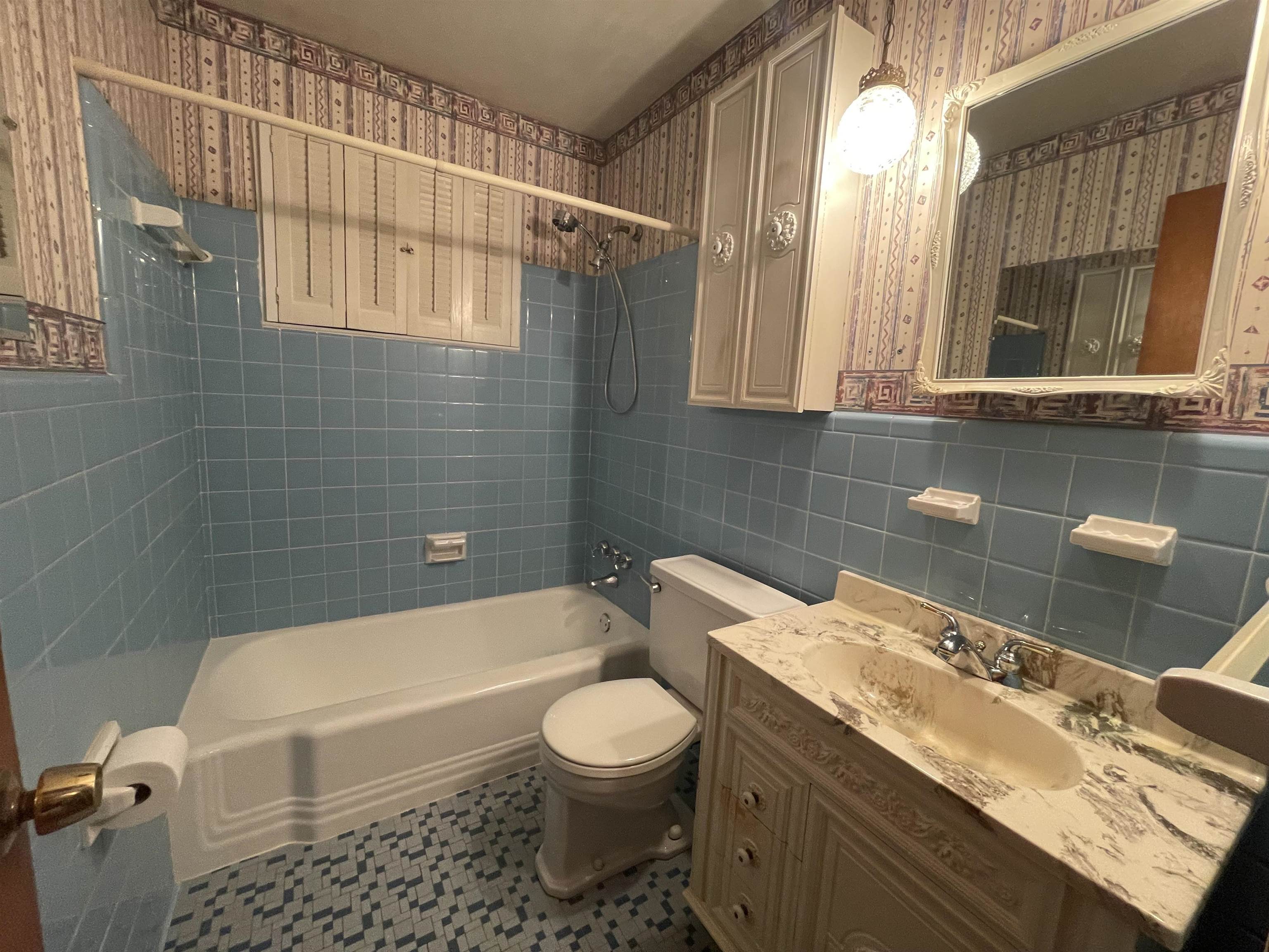 4857 Millbranch Road Memphis, TN 38116 - Photo 21 of 31 Full bathroom with tiled shower / bath, tile walls, toilet, and tile patterned floors