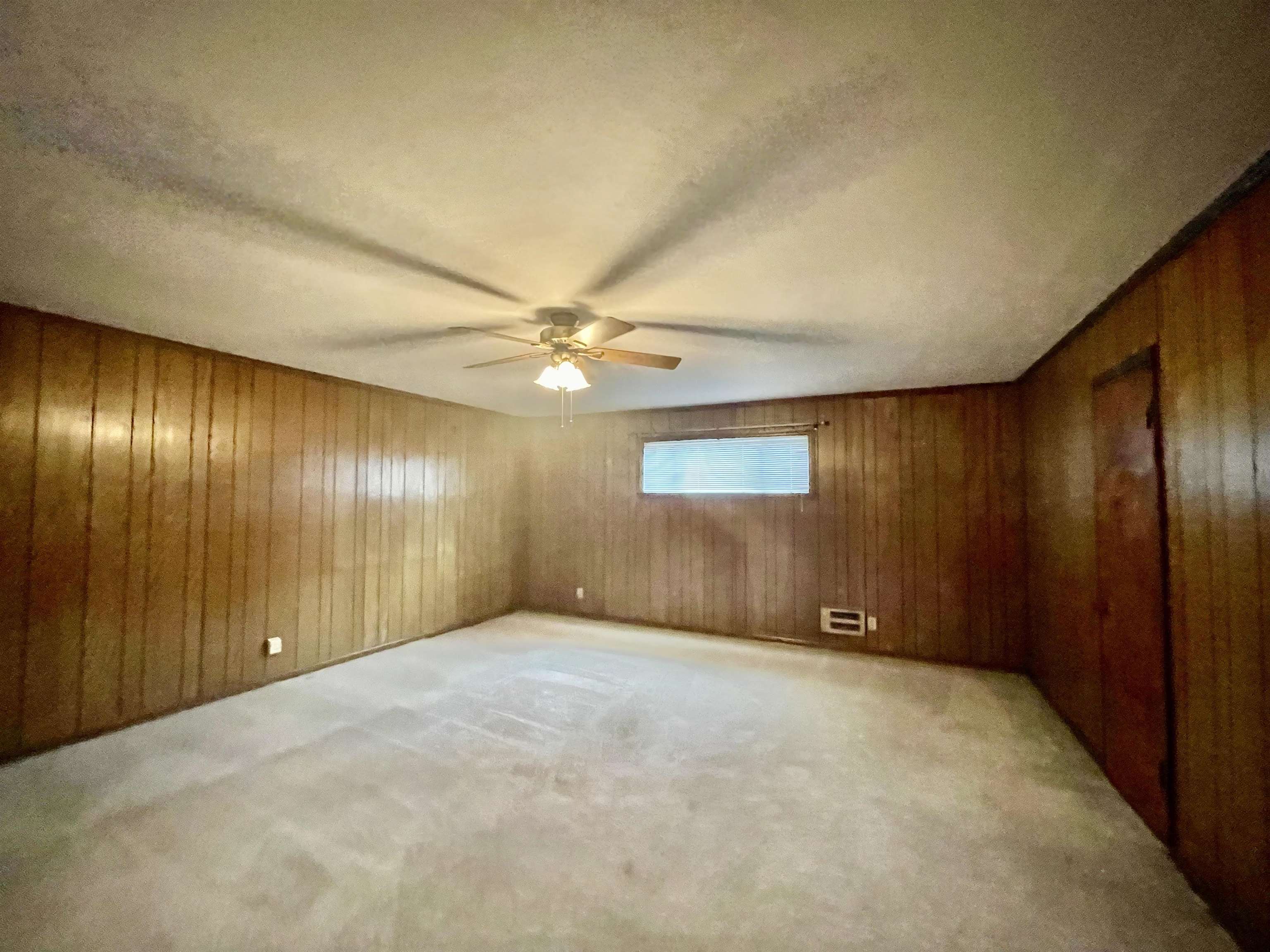 4857 Millbranch Road Memphis, TN 38116 - Photo 24 of 31 Carpeted spare room with wood walls and ceiling fan