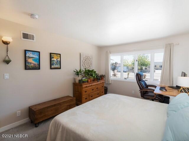 4061 Constellation Road Lompoc, CA 93436 - Photo 11 of 20 a bedroom with a bed a table chair and a window