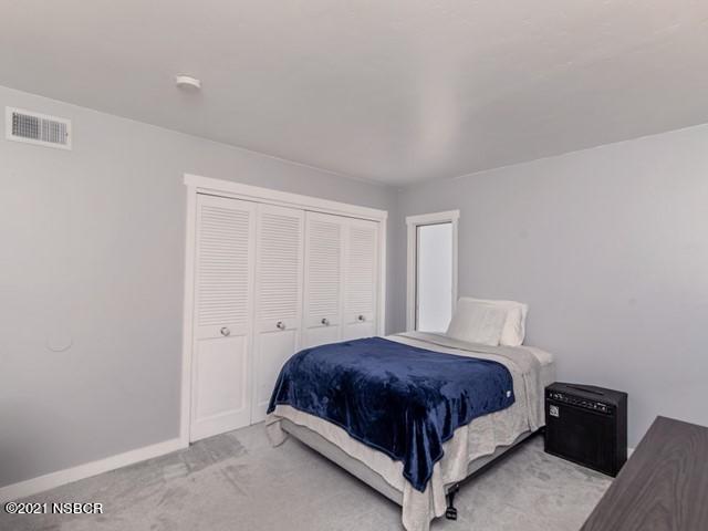 4061 Constellation Road Lompoc, CA 93436 - Photo 15 of 20 a bedroom with a bed lamp and a window