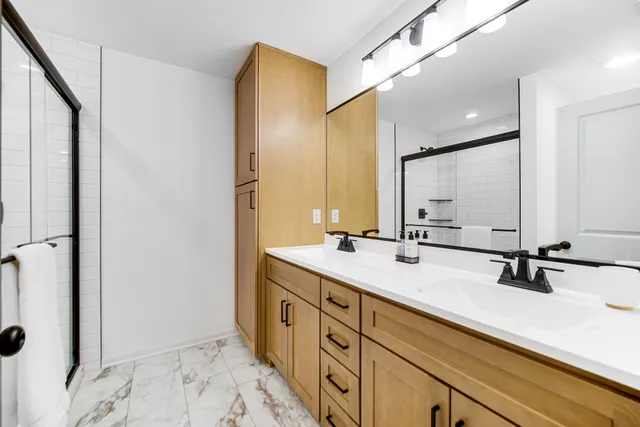 a bathroom with a double vanity sink a mirror and shower