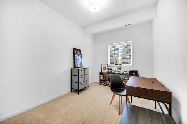 a view of a workspace with furniture and a window
