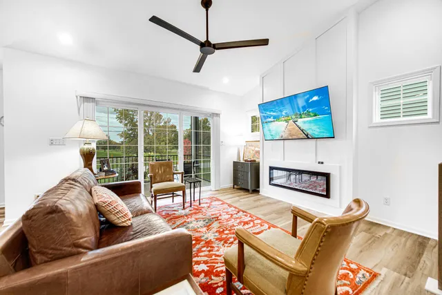 a living room with furniture a flat screen tv and a fireplace