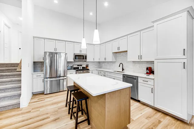 a kitchen with white cabinets and stainless steel appliances