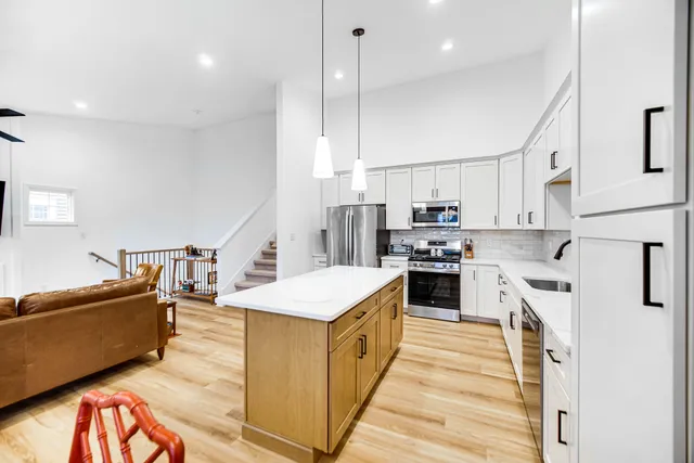 a kitchen with stainless steel appliances kitchen island wooden cabinets and a stove