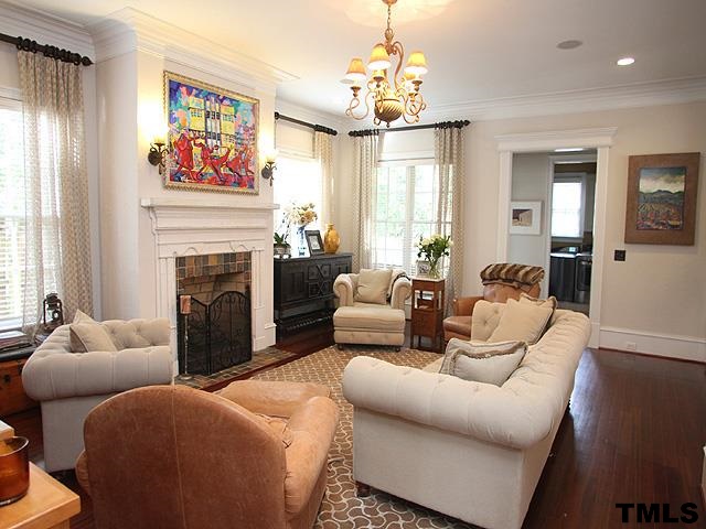2105 Cowper Drive Raleigh, NC 27608 - Photo 11 of 25 a living room with furniture a fireplace and a chandelier