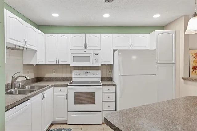 a white refrigerator freezer sitting inside of a kitchen
