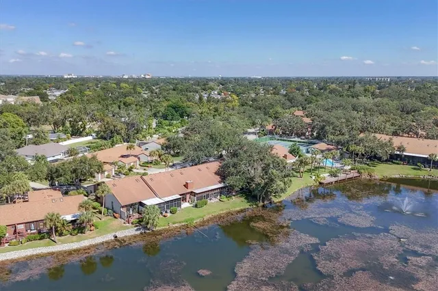 an aerial view of residential houses with outdoor space and trees