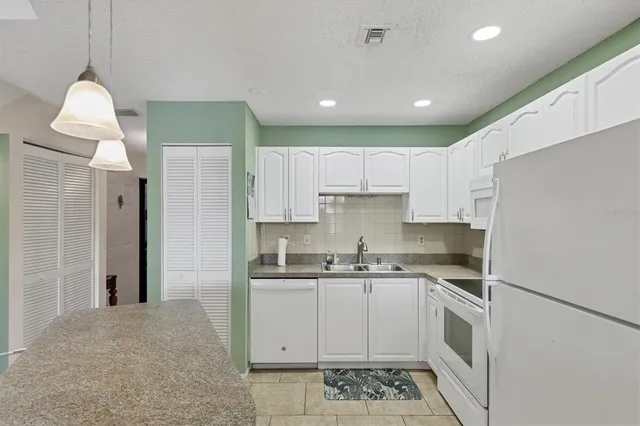 a kitchen with a sink stainless steel appliances and white cabinets
