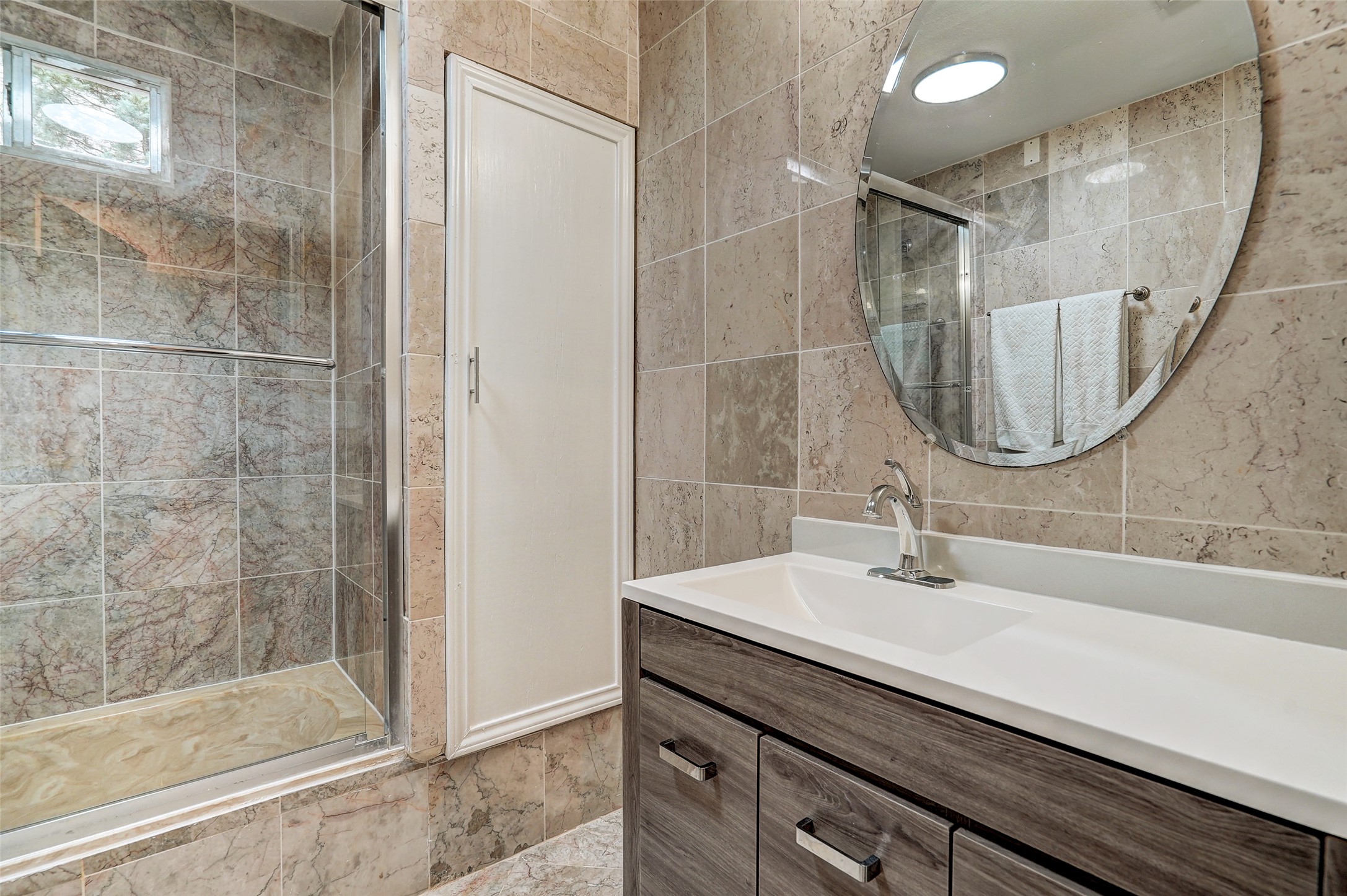 8804 Mountain Ridge Drive, Unit B Austin, TX 78759 - Photo 14 of 17 A well-appointed bathroom features a modern vanity with a sleek sink, set against elegant tiled walls.