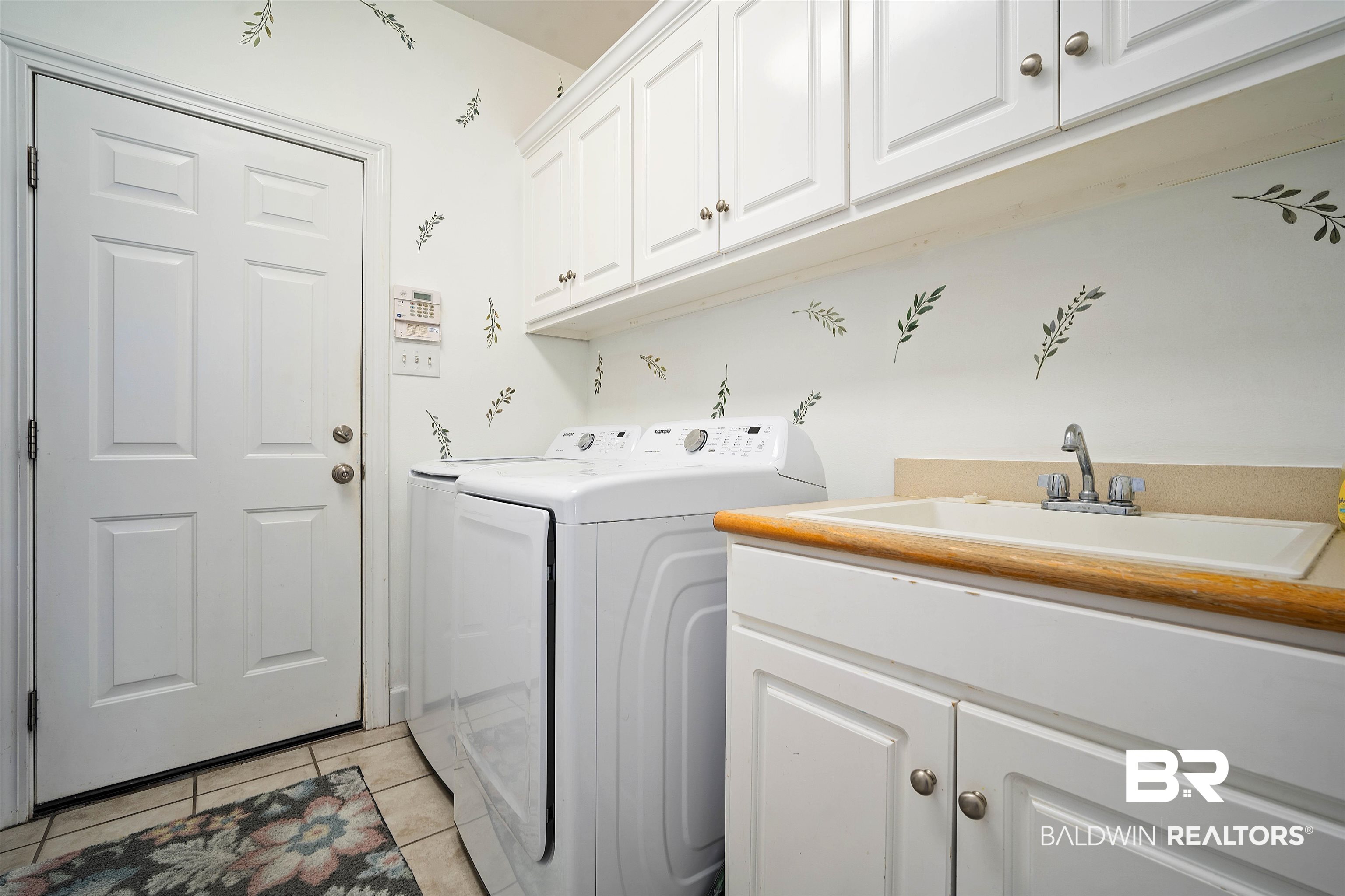 9552 White Castle Road Mobile, AL 36695 - Photo 28 of 31 Laundry area with washing machine and clothes dryer, a sink, light tile patterned floors, and cabinet space