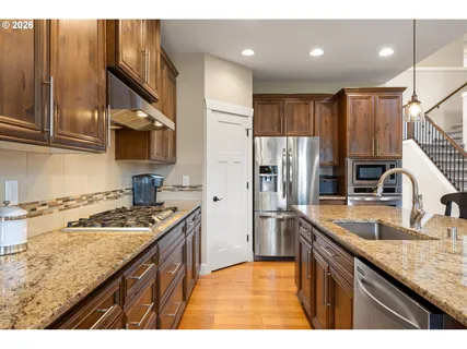 a kitchen with stainless steel appliances and refrigerator