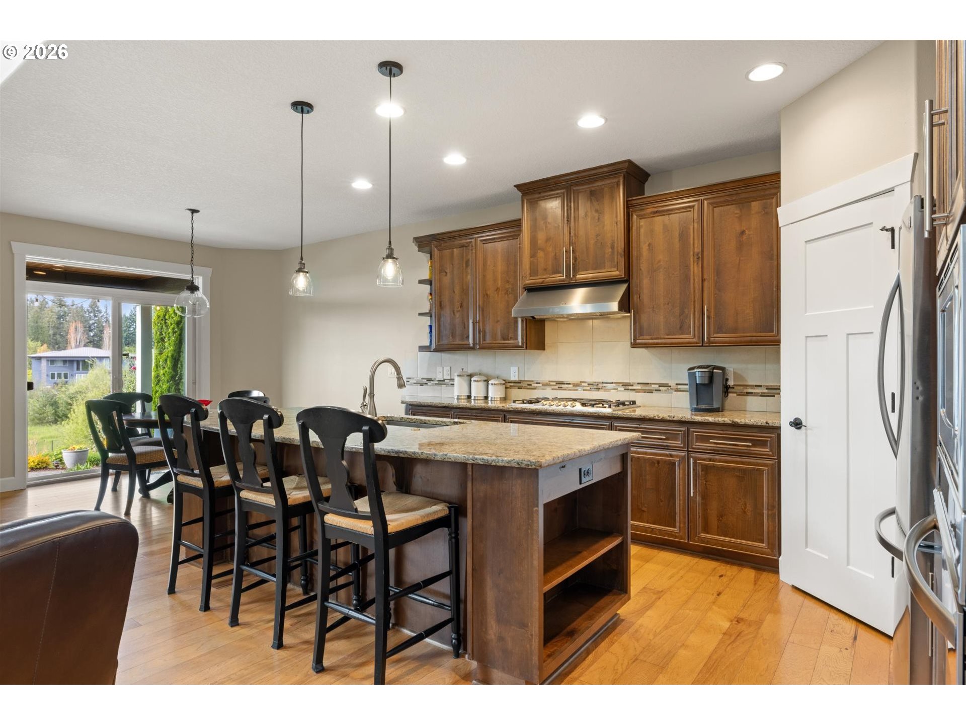 1274 South 15th Way Ridgefield, WA 98642 - Photo 9 of 46 a kitchen with kitchen island granite countertop wooden cabinets and white appliances