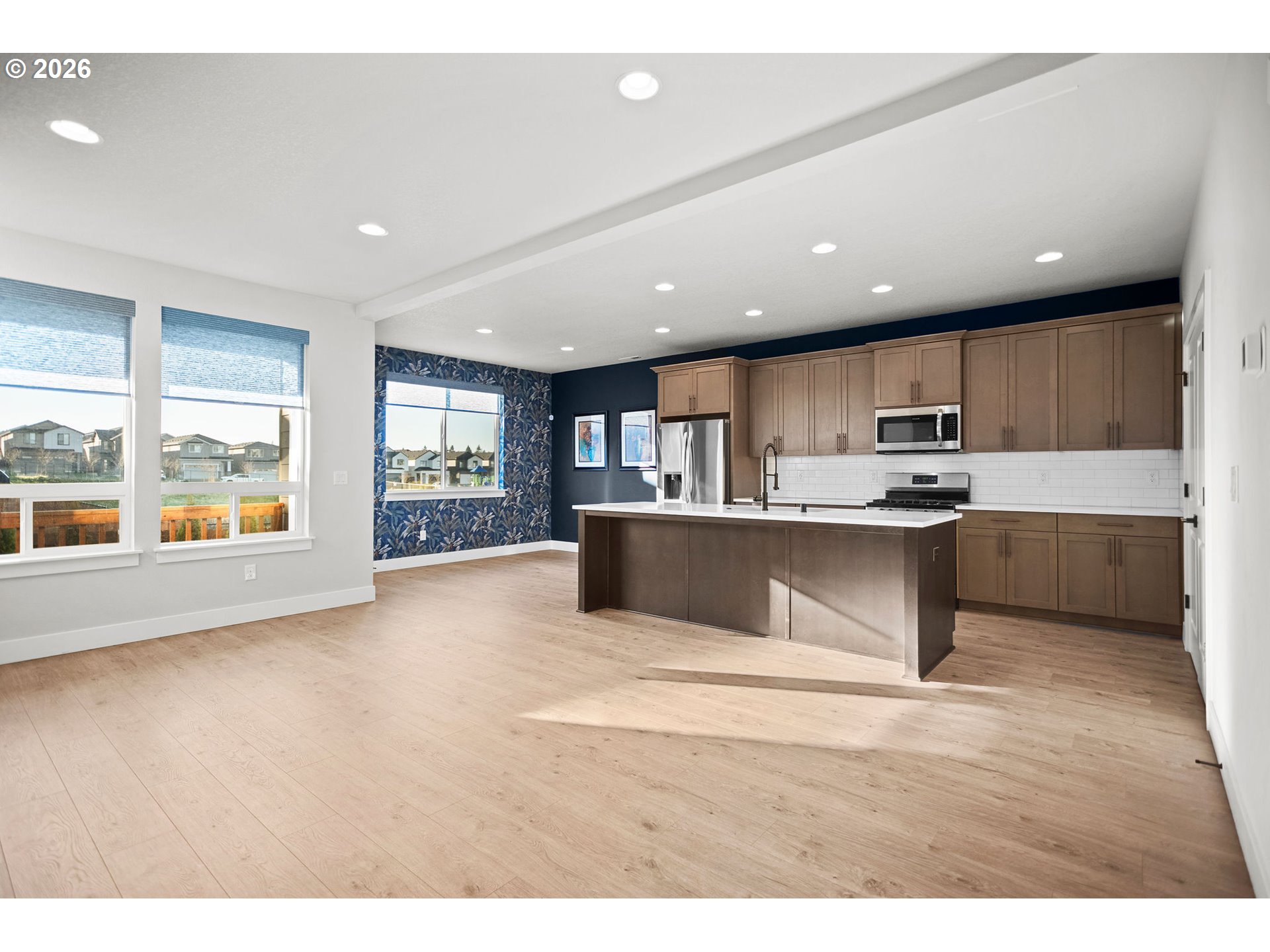 719 Northwest 178th Street Ridgefield, WA 98642 - Photo 12 of 46 a open kitchen with kitchen island a sink dishwasher stove with wooden cabinets and a counter top space