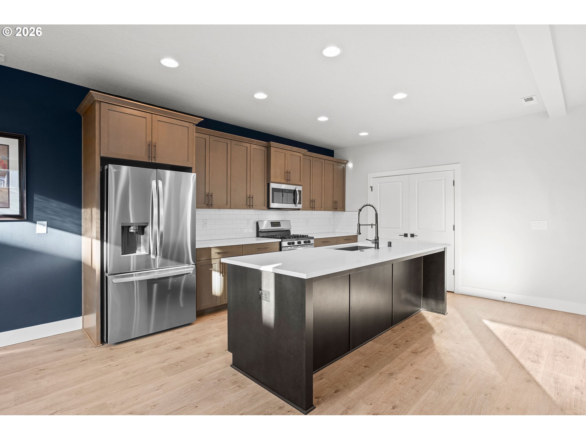 719 Northwest 178th Street Ridgefield, WA 98642 - Photo 14 of 46 a kitchen with stainless steel appliances kitchen island granite countertop a refrigerator and a sink