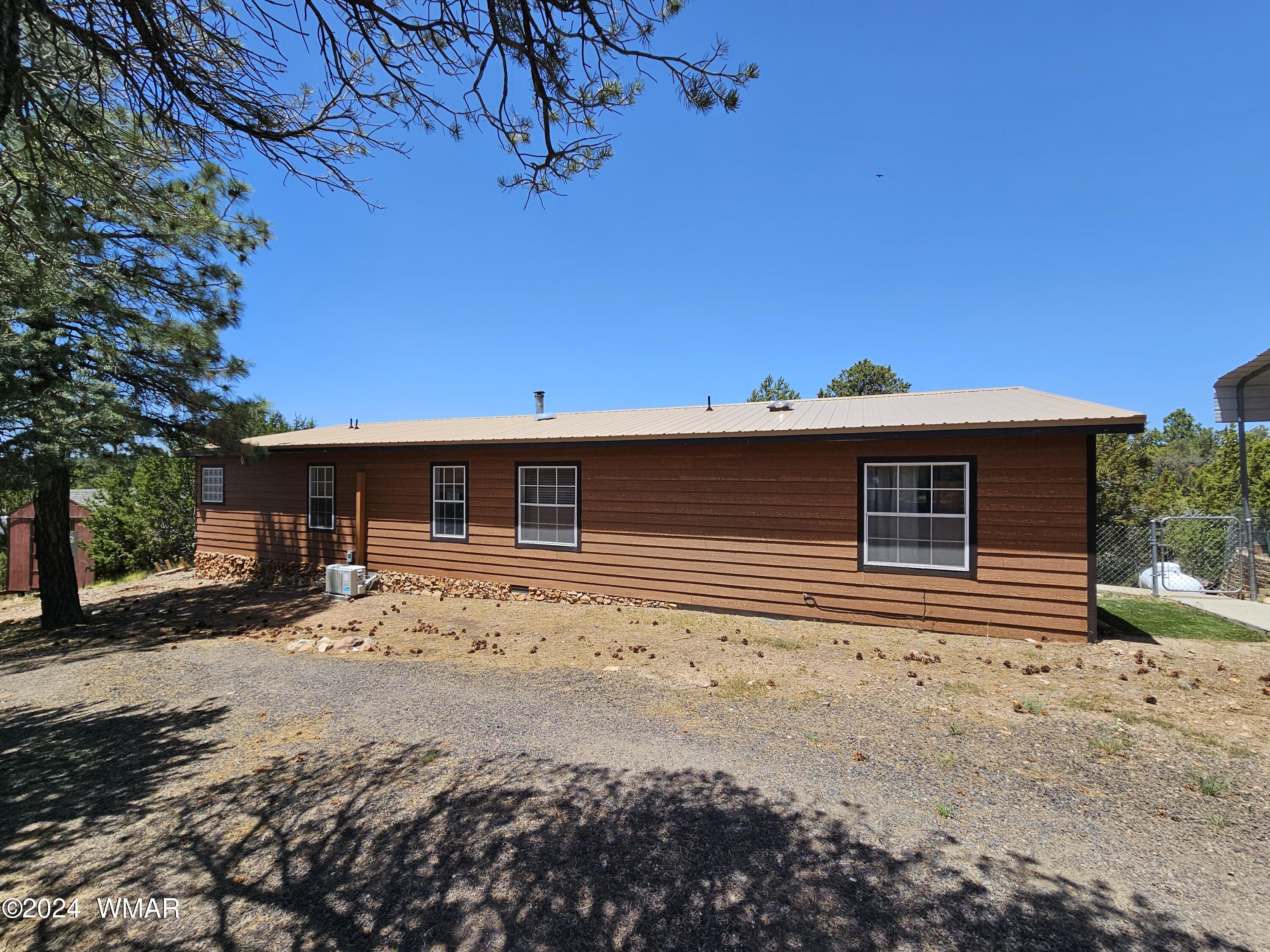 2896 Pine Rim Road Overgaard, AZ 85933 - Photo 3 of 17 a front view of a house with a yard