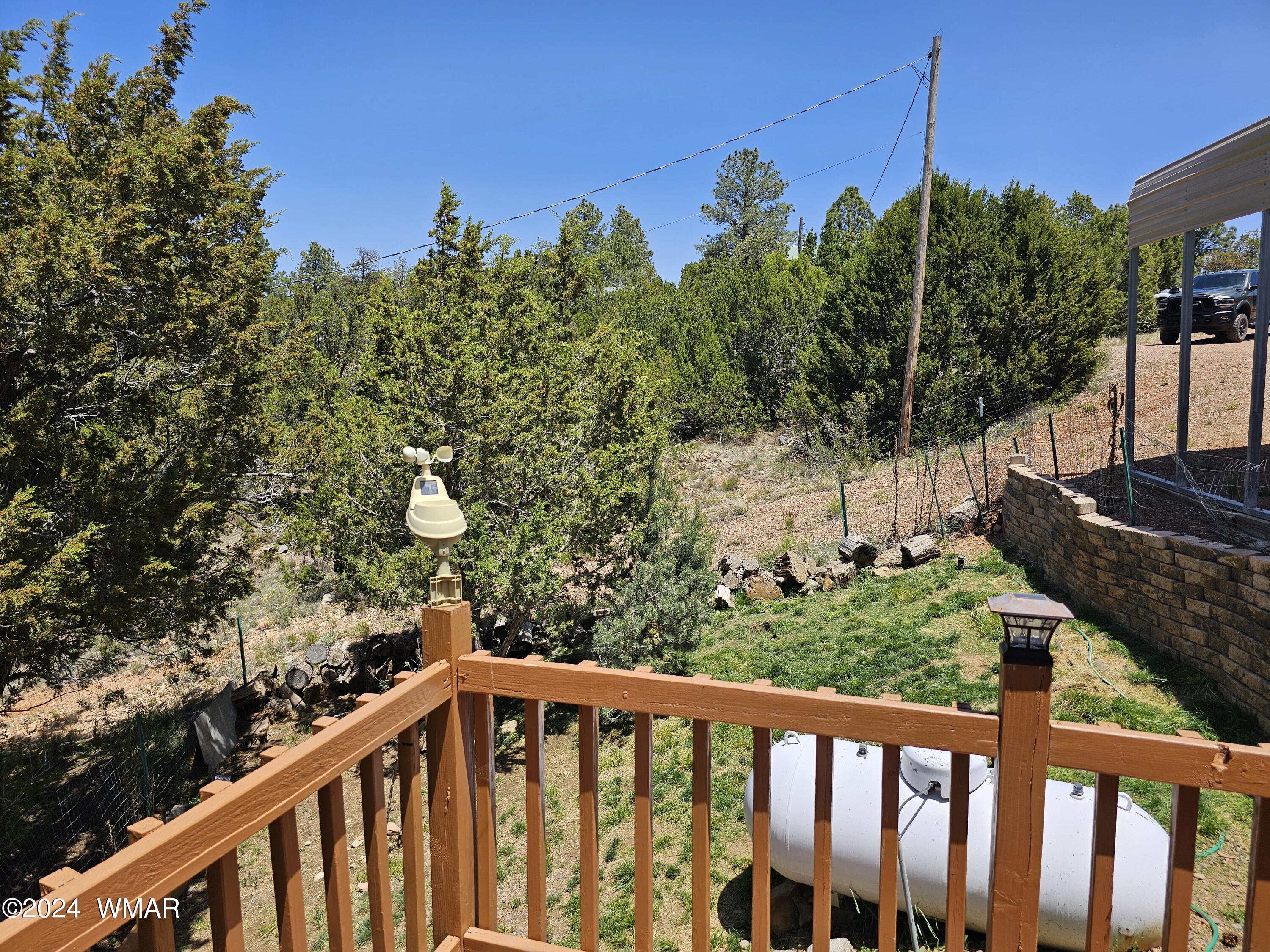 2896 Pine Rim Road Overgaard, AZ 85933 - Photo 8 of 17 a view of a wooden fence and trees in the background