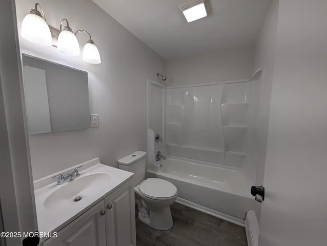 a bathroom with a bathtub shower sink mirror and toilet