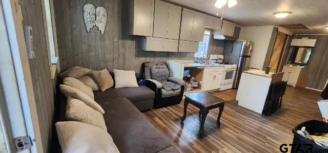 a living room with furniture and a wooden floor