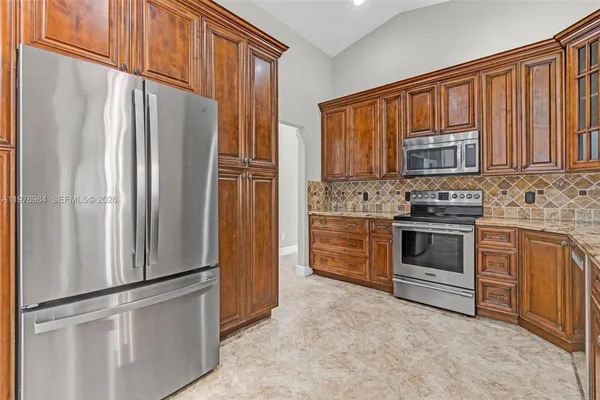 a kitchen with stainless steel appliances granite countertop a refrigerator stove and cabinets