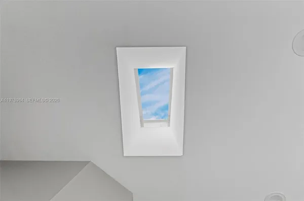 an empty room with wooden floor cabinet and windows