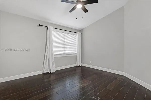 a view of an empty room with wooden floor
