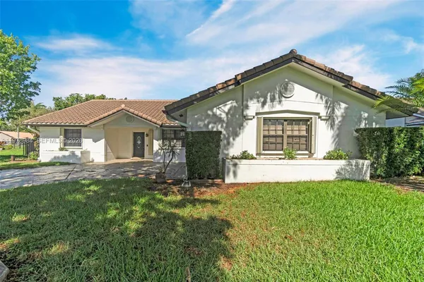 a view of a house with backyard and a tree