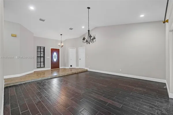 a view of a room with wooden floor and ceiling fan