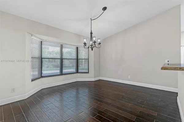 a view of wooden floor and a chandelier in a room