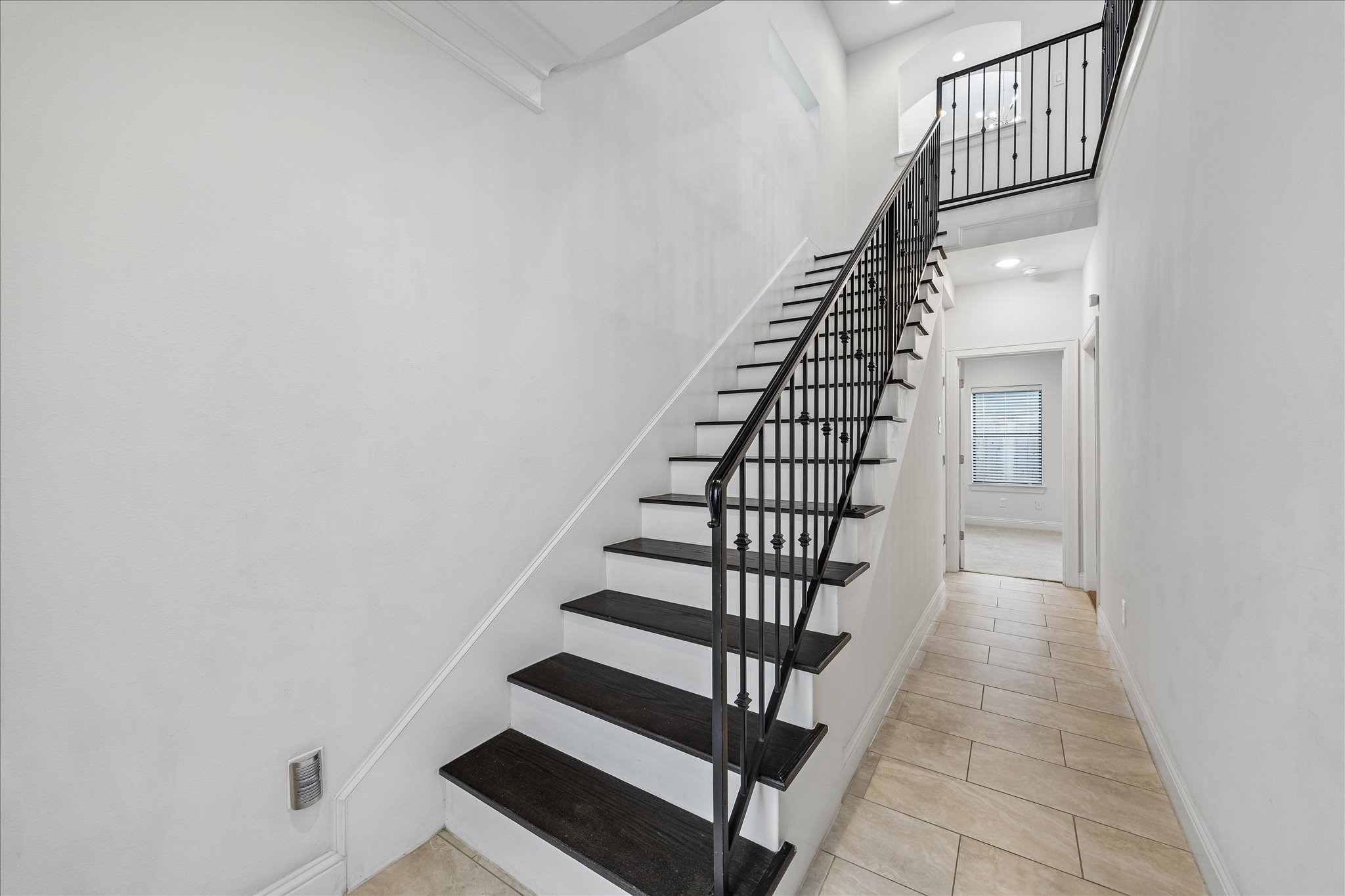 734 West 20th Street, Unit A Houston, TX 77008 - Photo 22 of 23 Welcoming first-floor entry features tile flooring & a clean, open hallway, anchored by a staircase w/ rich wood treads & iron railing detail leading to the main living level.