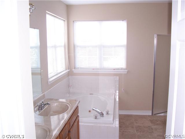 1208 Tree Ridge Road Henrico, VA 23231 - Photo 14 of 21 a bathroom with a tub a sink and a window