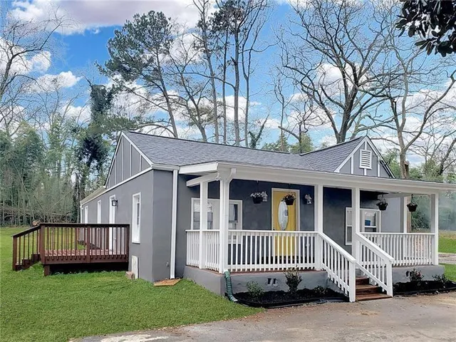 a front view of a house with a garden and deck