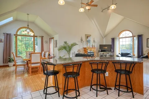 a dining room with furniture a chandelier and wooden floor