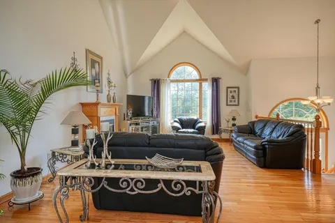 a living room with furniture fireplace and a large window