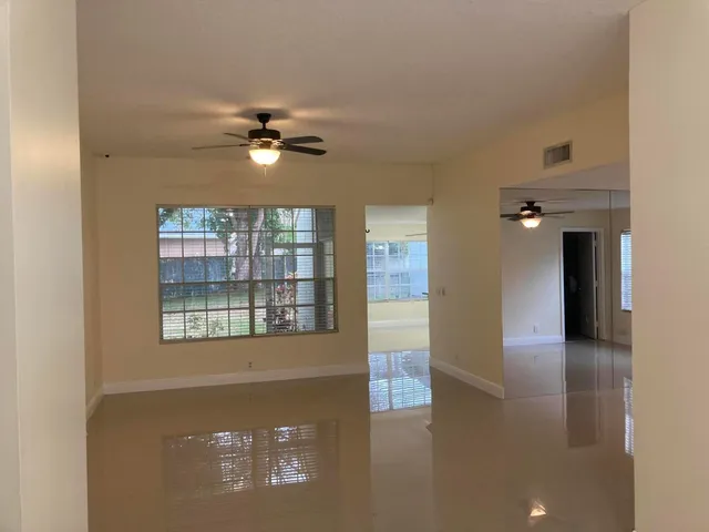 a view of a livingroom with a ceiling fan and window
