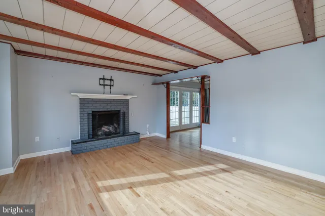 a view of empty room with wooden floor and fireplace