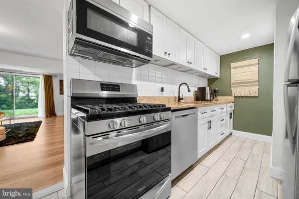 a kitchen with stainless steel appliances granite countertop a stove and a microwave