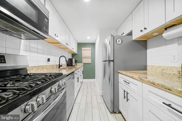 a kitchen with stainless steel appliances granite countertop a stove and a refrigerator