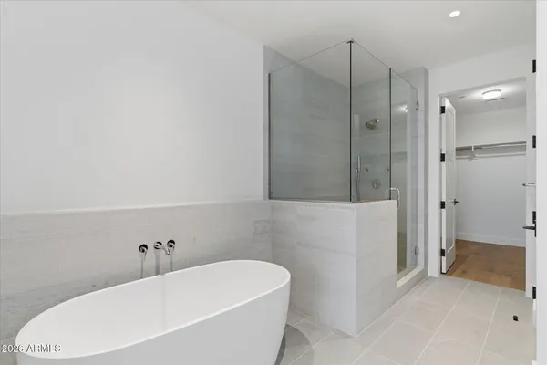 a bathroom with a tub sink and mirror