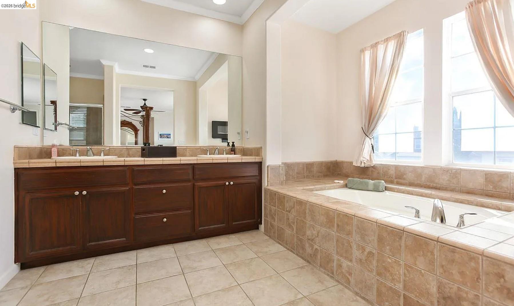 3251 Lookout Point Loop Discovery Bay, CA 94505 - Photo 16 of 31 Bathroom with double vanity, a garden tub, crown molding, light tile patterned floors, and ceiling fan