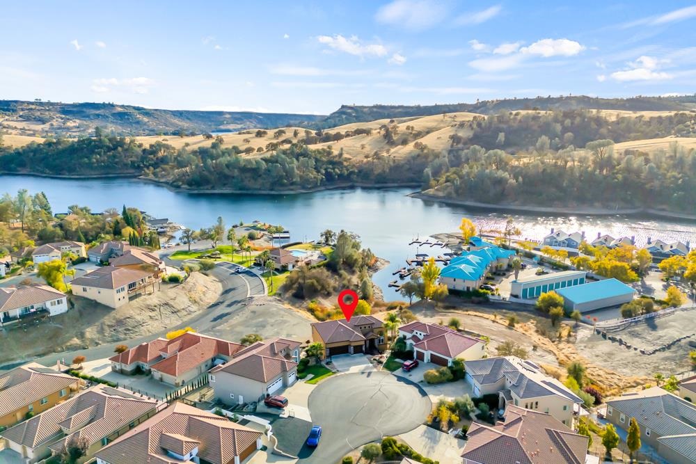 an aerial view of ocean and residential houses with outdoor space