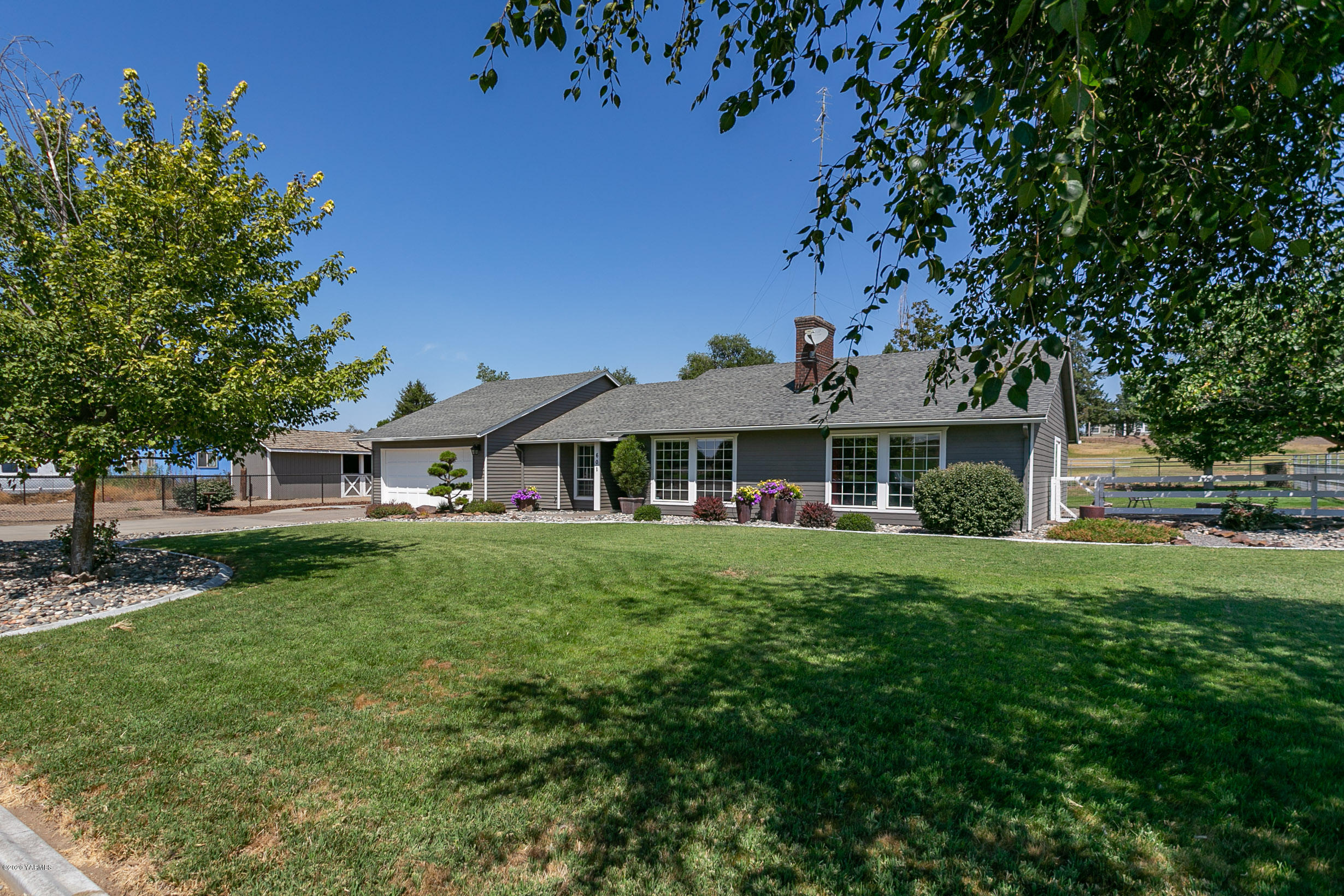 601 Brewer Road Grandview, WA 98930 - Photo 1 of 32 a front view of a house with a garden