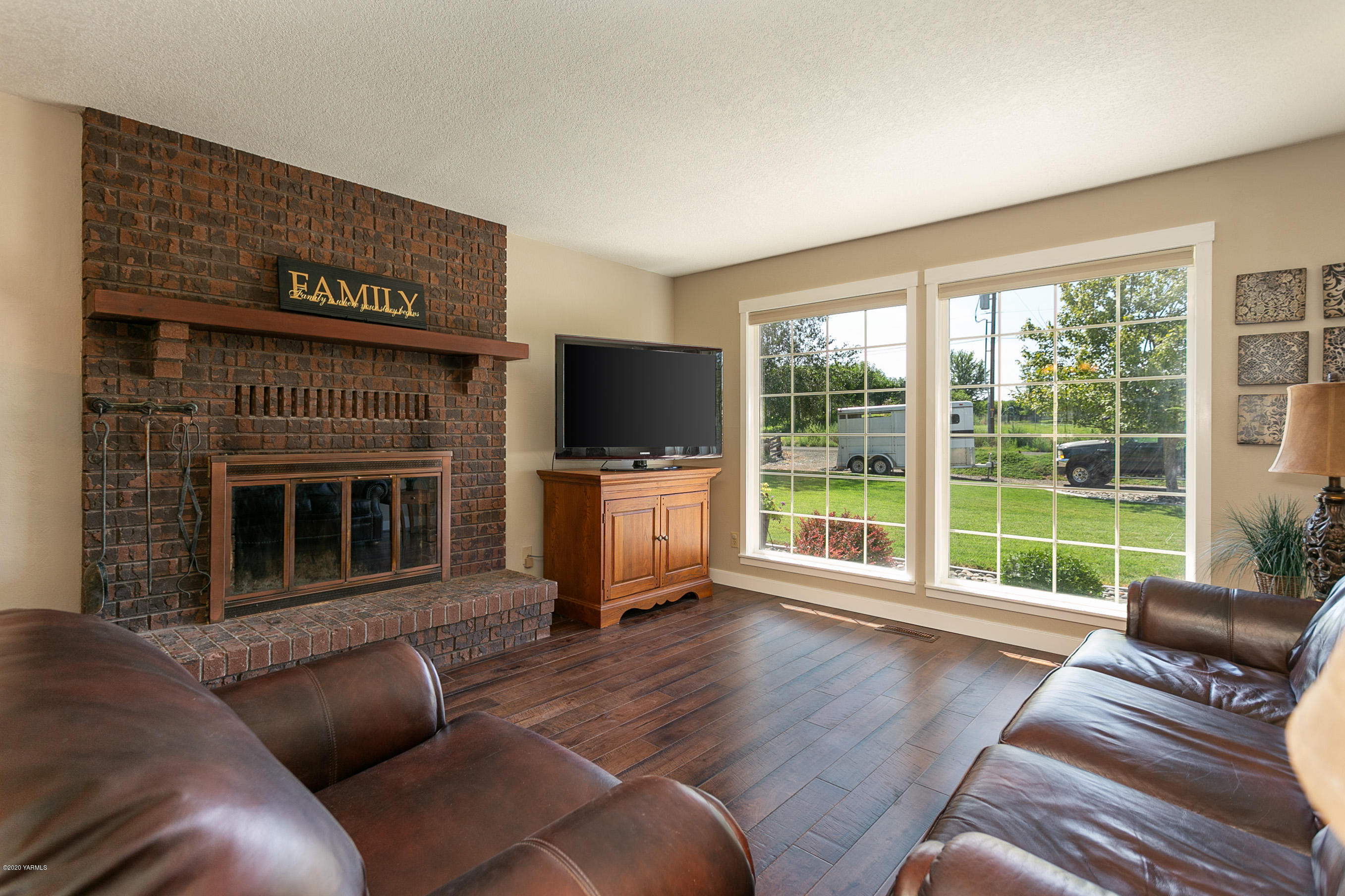 601 Brewer Road Grandview, WA 98930 - Photo 4 of 32 a living room with furniture a flat screen tv and a fireplace