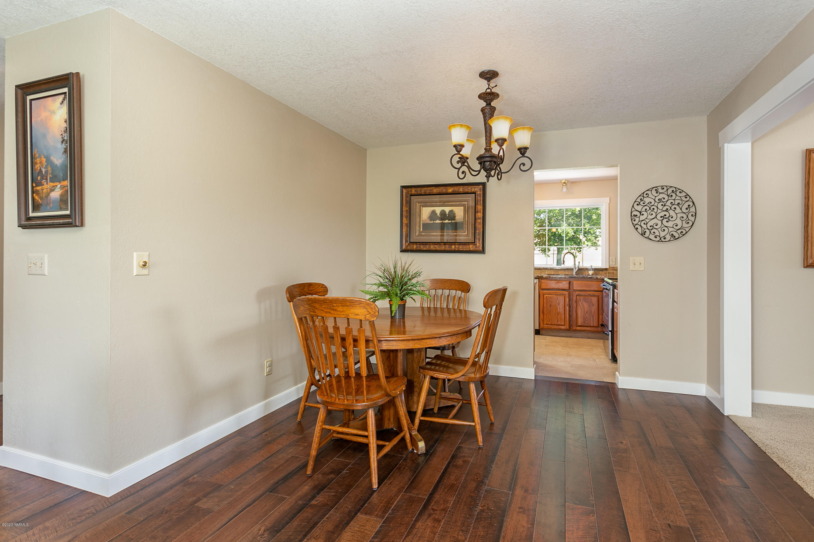 601 Brewer Road Grandview, WA 98930 - Photo 5 of 32 a view of a dining room with furniture wooden floor and a chandelier