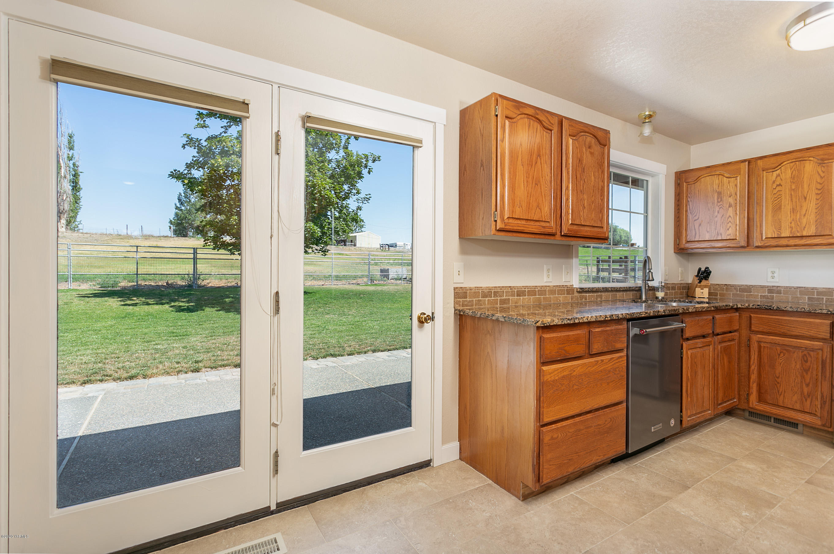 601 Brewer Road Grandview, WA 98930 - Photo 10 of 32 a kitchen with granite countertop a stove a sink and a refrigerator